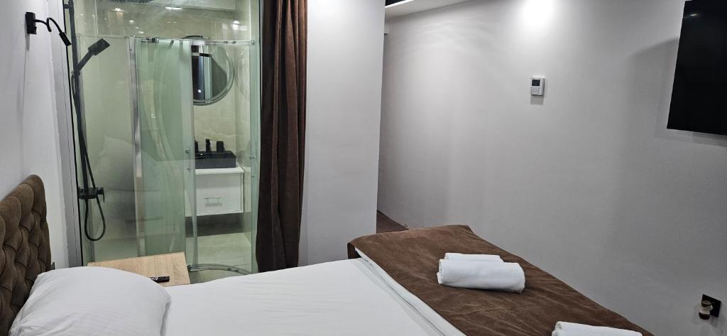 a room with a shower and a bed and a glass door at Apartmani COLOSSEUM in Bratunac