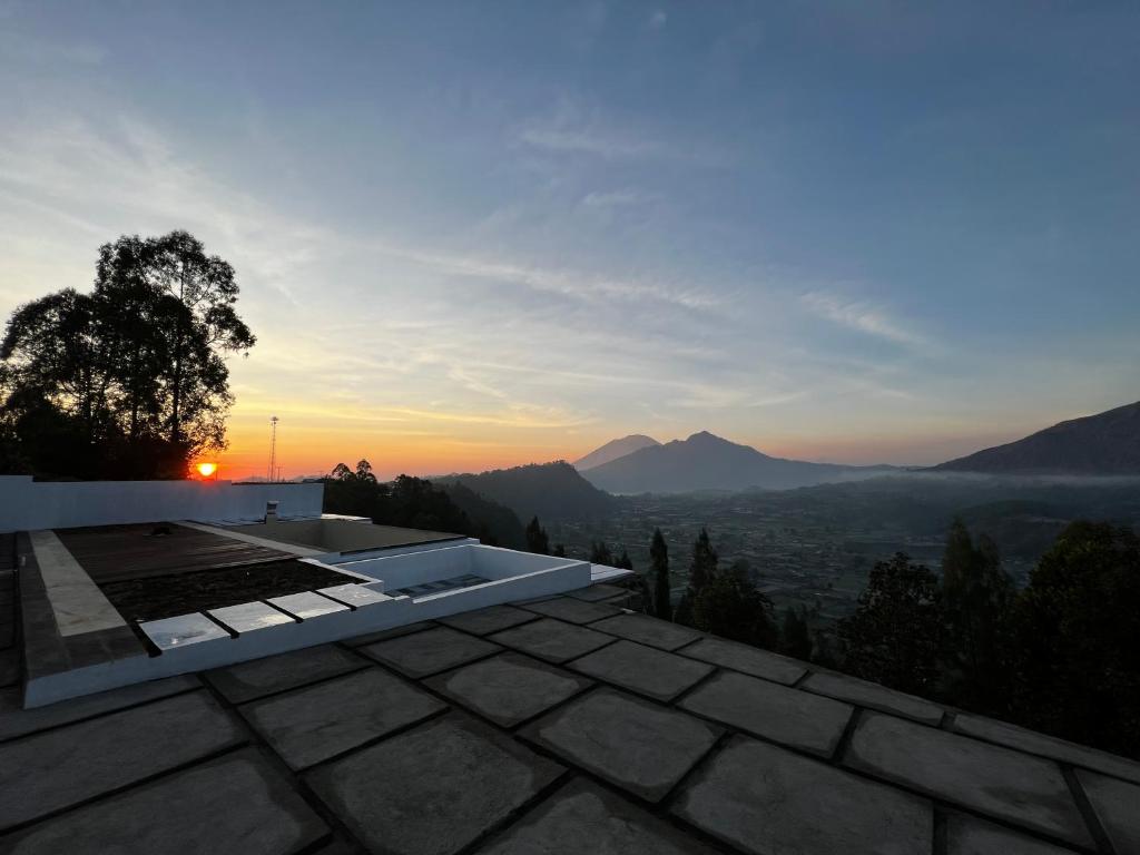 uma vista para o pôr-do-sol a partir do telhado de uma casa em Highland Bali em Baturaja
