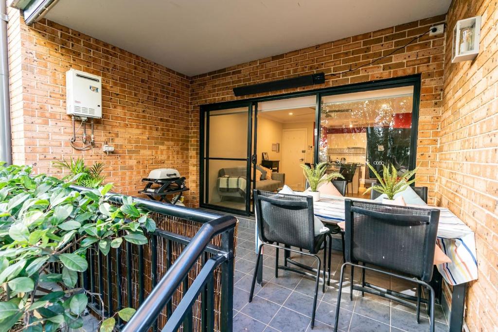 a patio with a table and chairs on a balcony at Funda Place - Leafy Hideout in Northern Beaches in Sydney