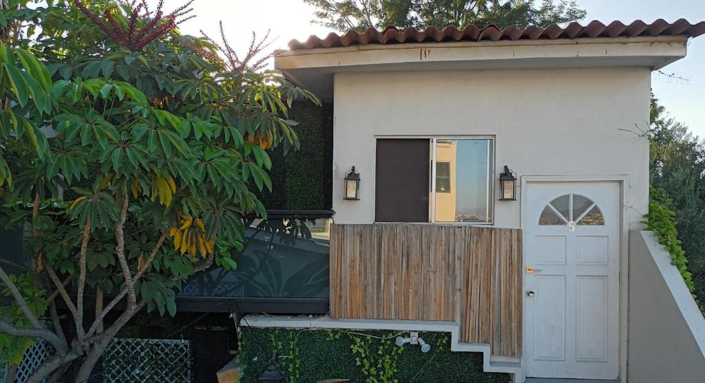 a small house with a white door and a fence at Tree Cabin in Tijuana