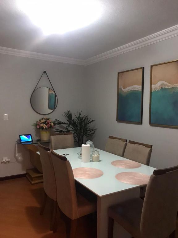 布盧梅瑙的住宿－Quarto para Casal Blumenau，一间配备有白色桌椅的用餐室