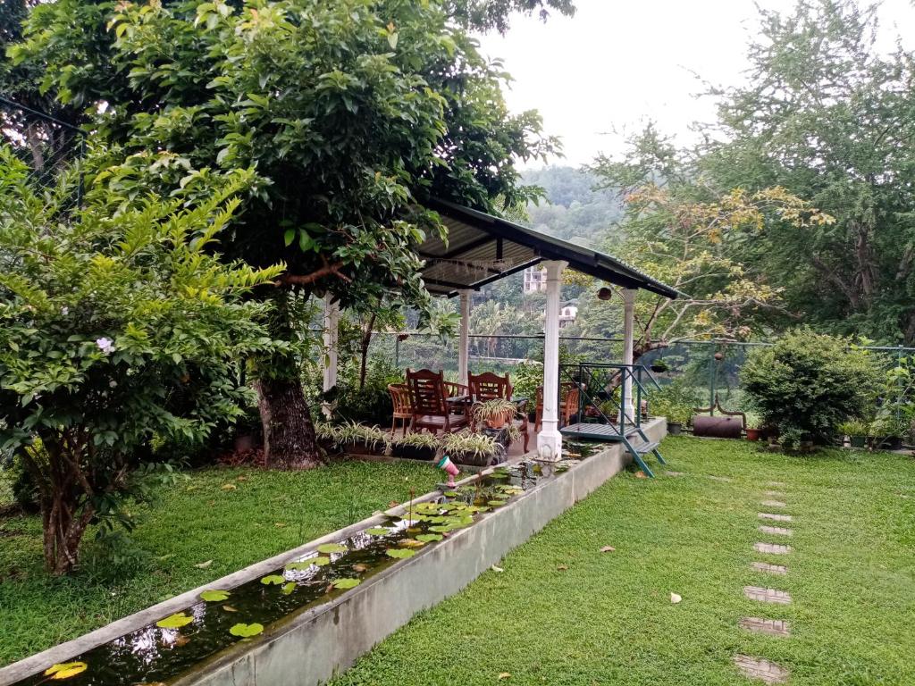 a garden with a gazebo and chickens in a yard at Mahaweli Shades in Kandy
