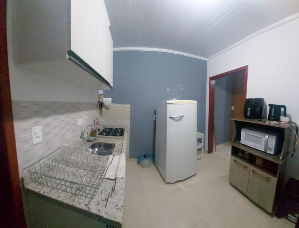 a kitchen with a refrigerator and a microwave at Cleyton Morada in Curitiba