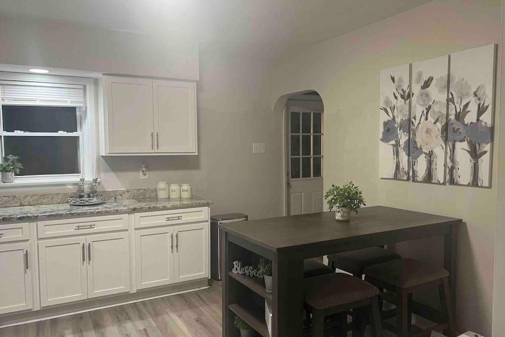 a kitchen with white cabinets and a table and chairs at Cozy Home Away from Home in Clayton