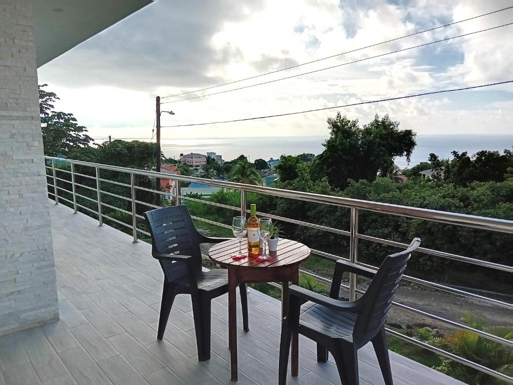 einen Tisch und Stühle auf einem Balkon mit Meerblick in der Unterkunft Serenity Seaview Suite in Anse La Raye