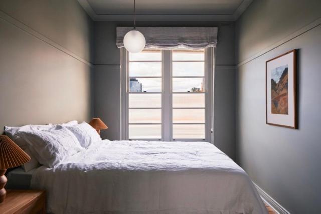 a bedroom with a bed in front of a window at The Courthouse Hotel in Melbourne