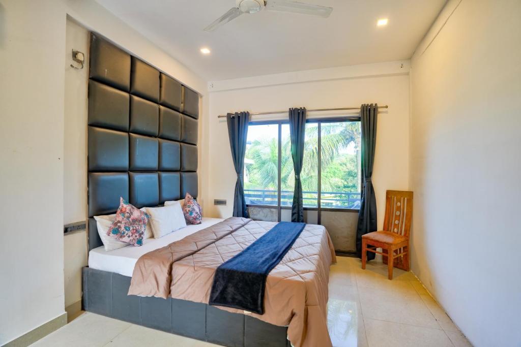 a bedroom with a large bed and a window at GOA Down D Vilage Prime in Candolim