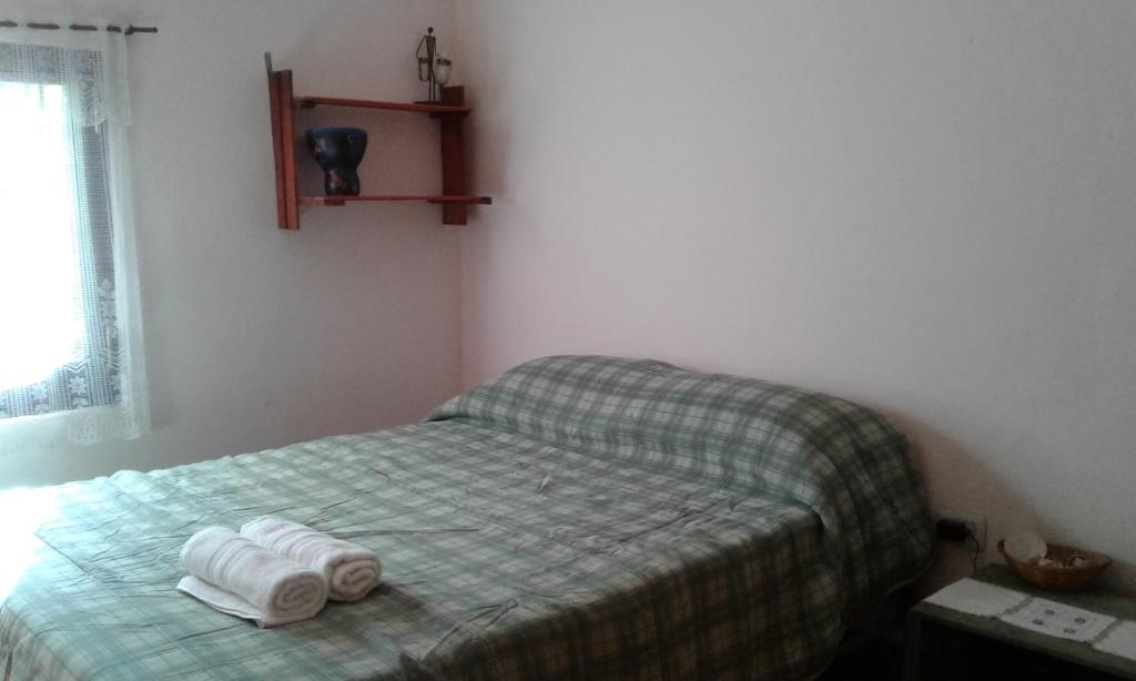 1 dormitorio con 1 cama con 2 toallas en Habitacion privada Stella Maris en Río Ceballos
