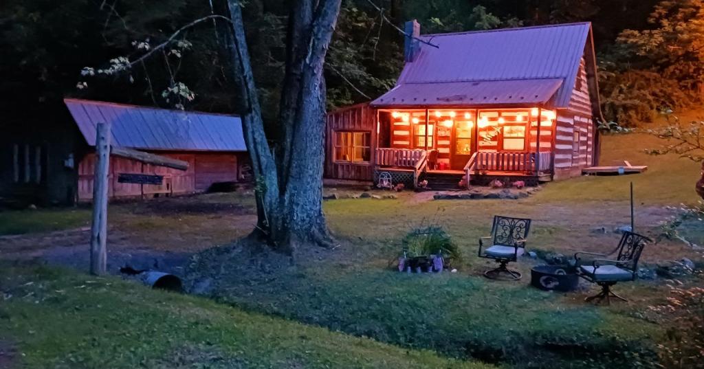 een blokhut 's nachts met verlichting aan bij The Little Cabin on Huckleberry in Rural Retreat