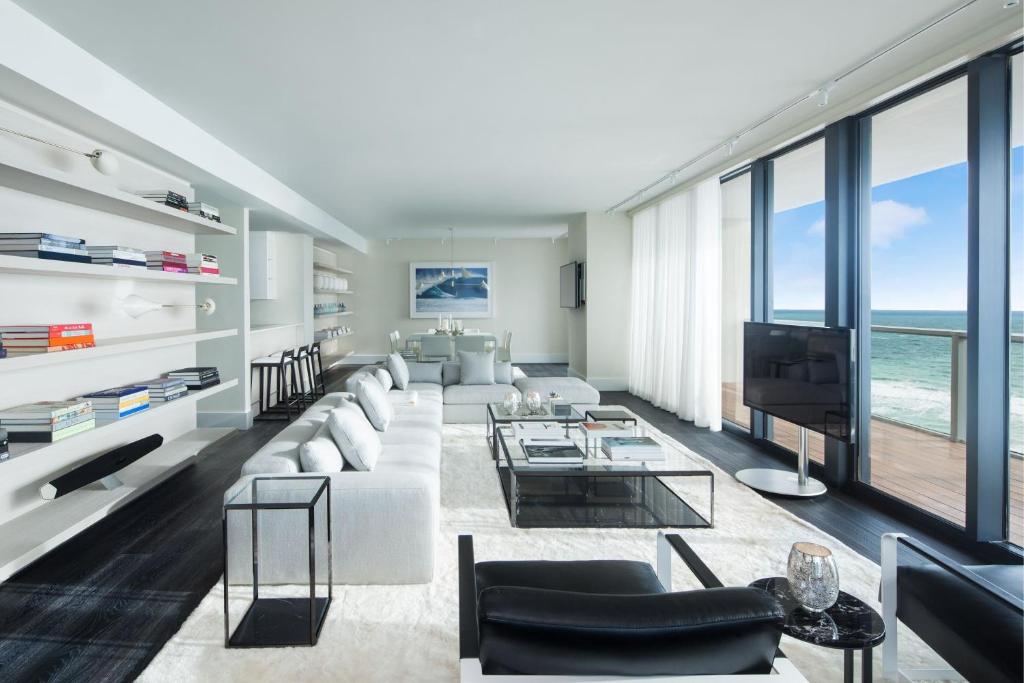 a living room with a large couch and a television at W South Beach in Miami Beach