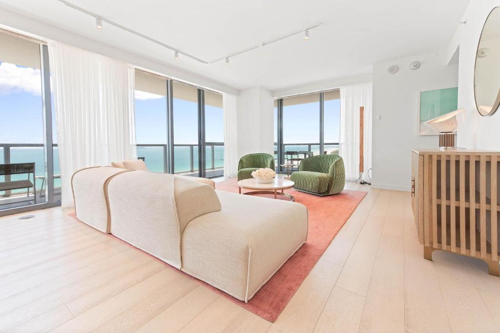 a living room with a white couch and glass windows at W South Beach in Miami Beach