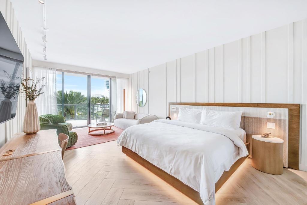 a bedroom with a large bed and a living room at W South Beach in Miami Beach