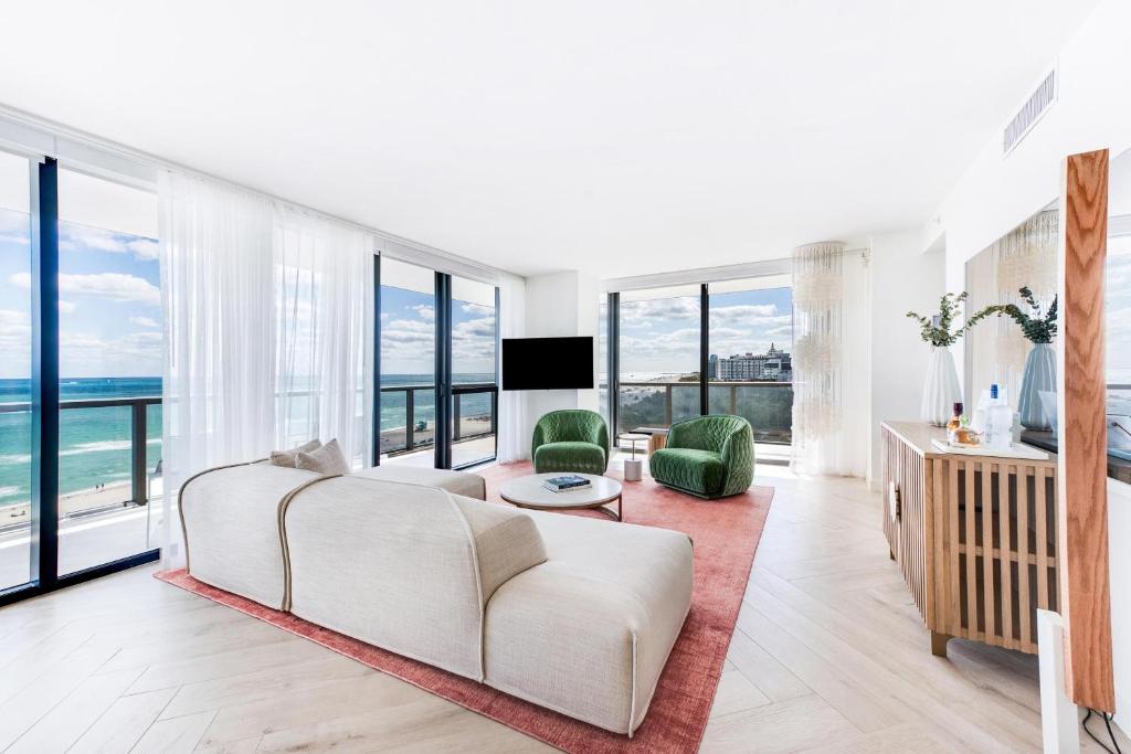 a living room with a white couch and large windows at W South Beach in Miami Beach
