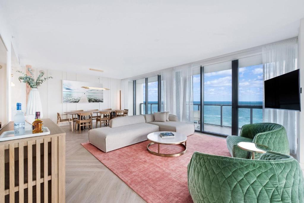 a living room with a couch and chairs and a television at W South Beach in Miami Beach