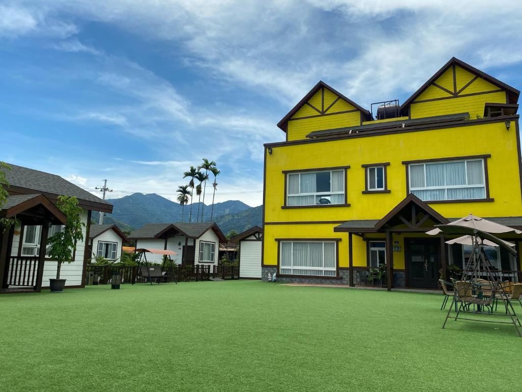 un edificio amarillo con césped delante en Puli Diary en Puli