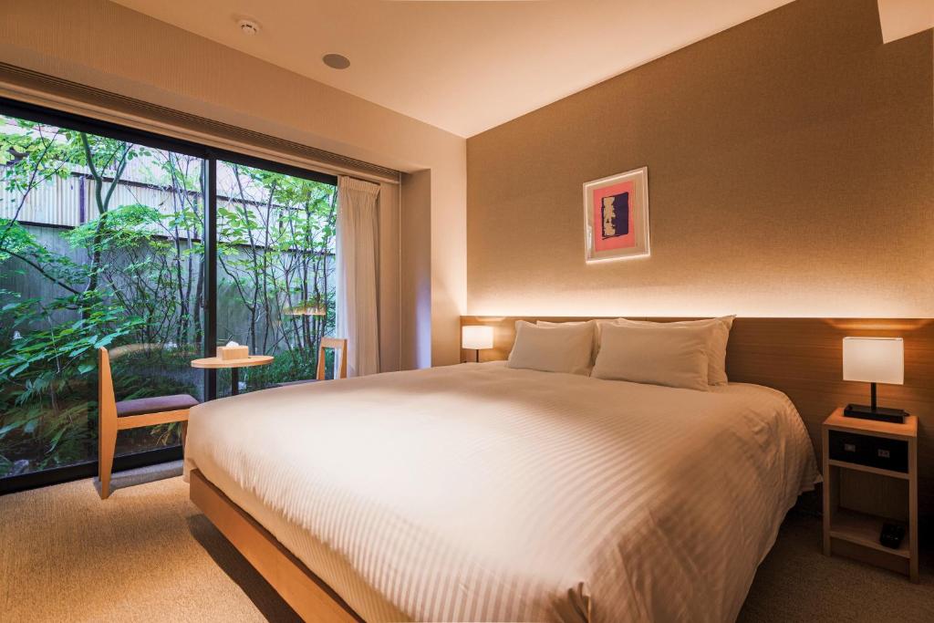 a bedroom with a large bed and a large window at KABIN Koji in Kyoto