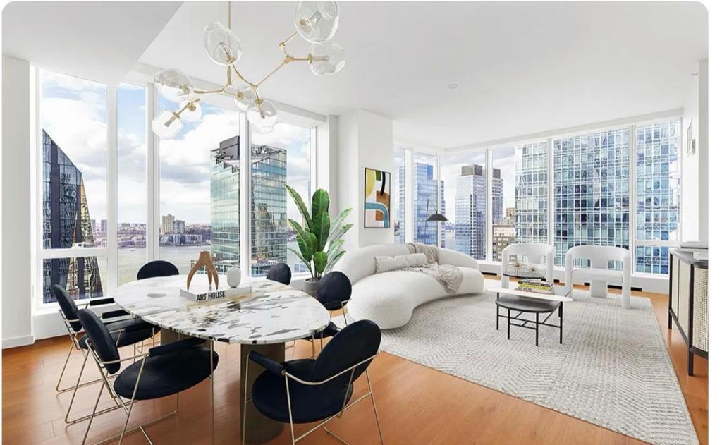 een woonkamer met een tafel en stoelen en een bank bij Stunning views of Manhattan in New York