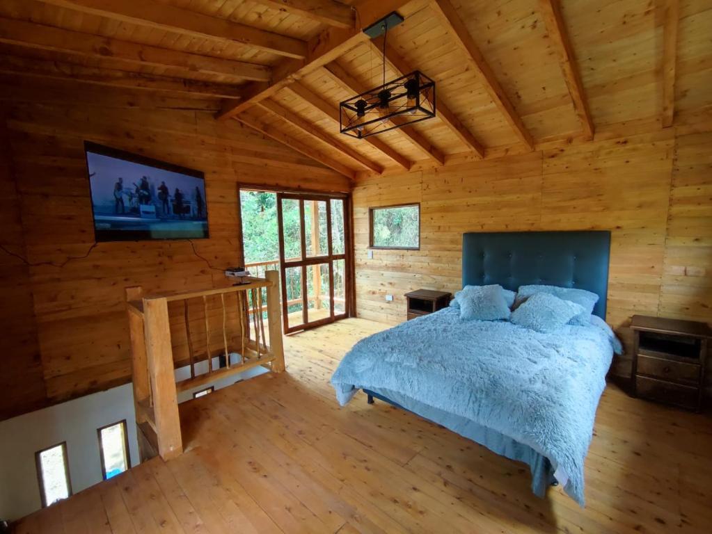 1 dormitorio con 1 cama en una cabaña de madera en cabaña paniym, en Rionegro