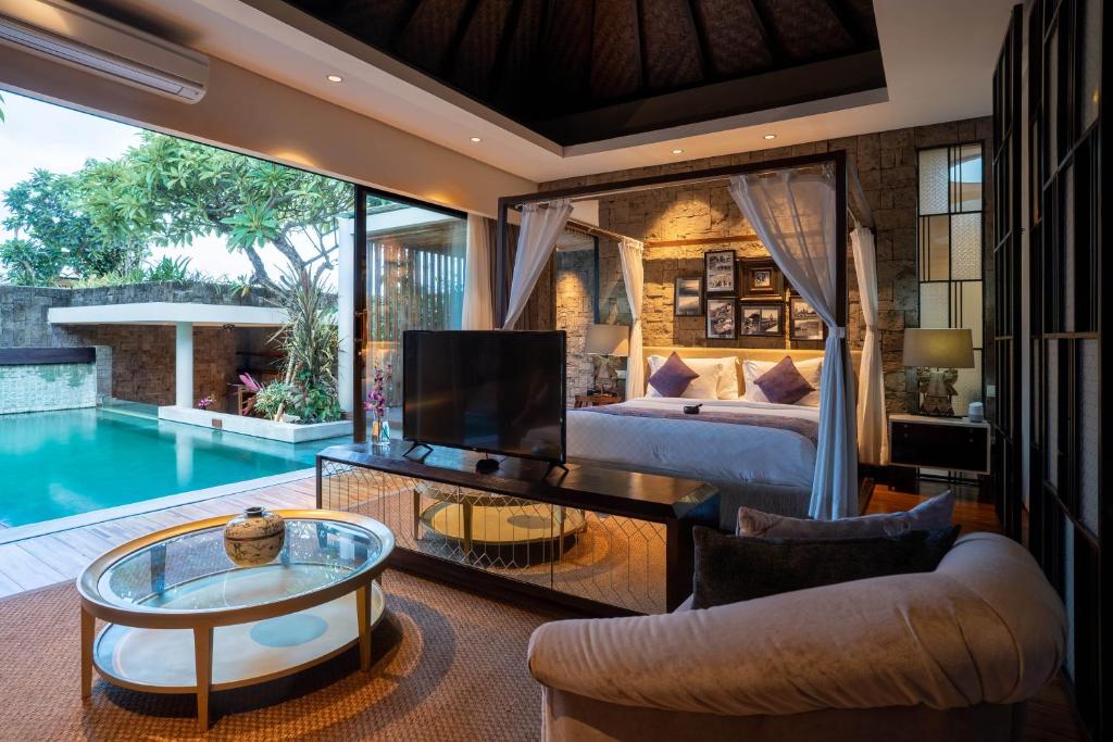 a living room with a bed and a pool at Berry Amour Romantic Villas in Seminyak