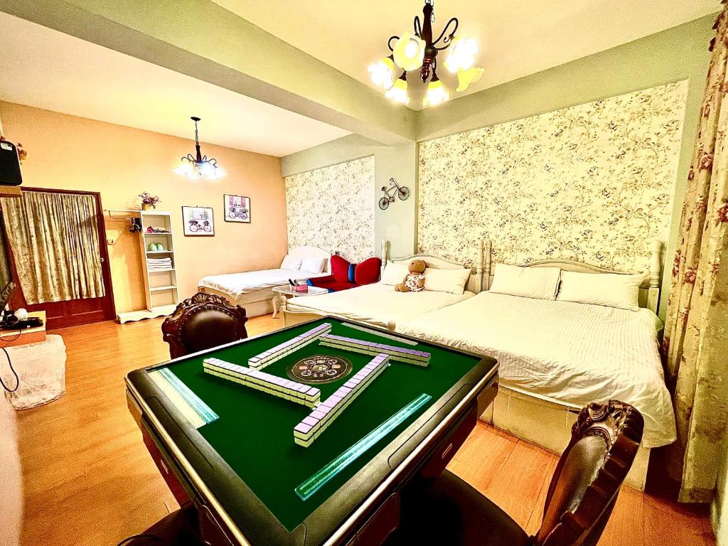 a room with a bed and a poker table in it at 五指山遠百民宿-免費停車場-6人家庭房附電動麻將桌 in Hualien City