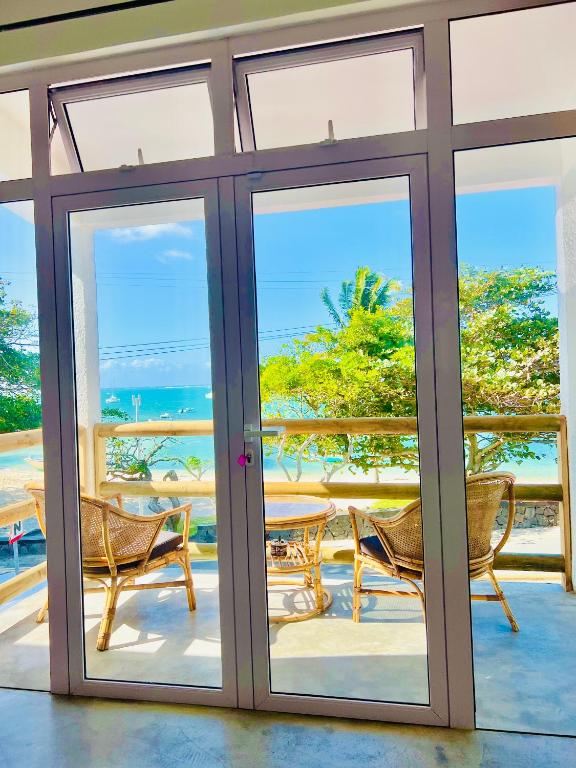 a patio door with a view of the ocean at Villa SempreViva in Trou d'Eau Douce