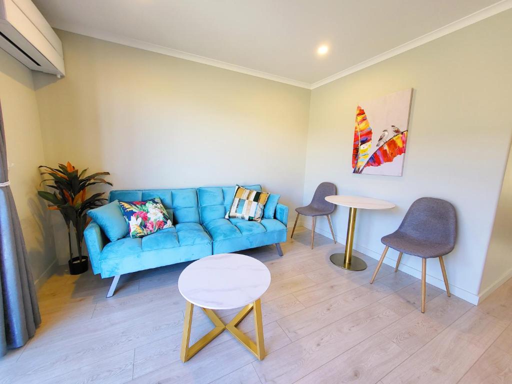 a living room with a blue couch and a table at White Stone Apartment in Lake Tekapo