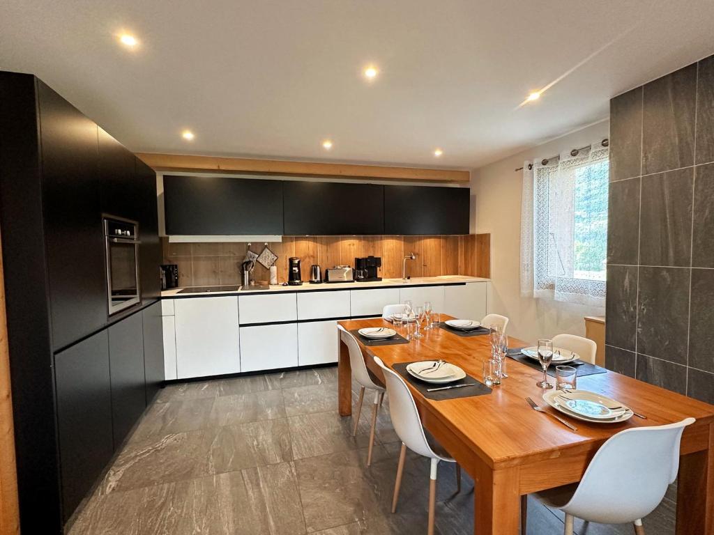 a kitchen with a wooden table and white cabinets at Appartement Morillon Village, 3 pièces, 5 personnes - FR-1-624-141 in Morillon