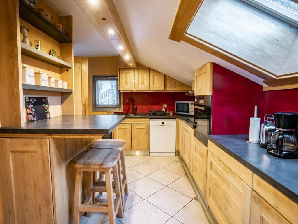 uma cozinha com armários de madeira e um balcão com bancos em Appartement Châtel, 4 pièces, 6 personnes - FR-1-676-60 em Châtel