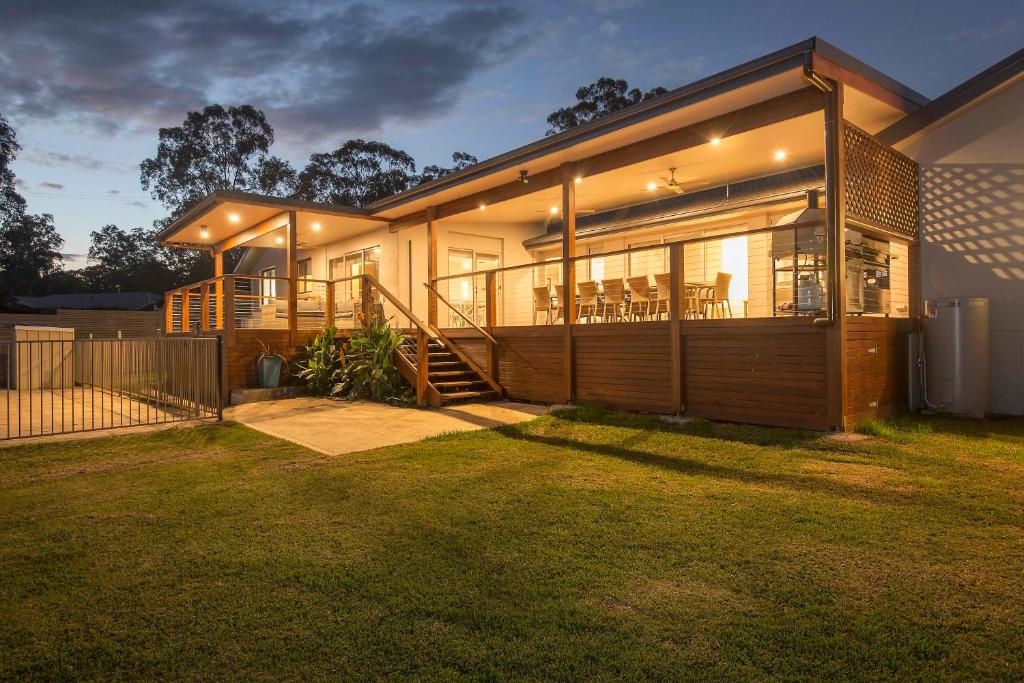 a large house with a porch and a deck at Amani in Pokolbin