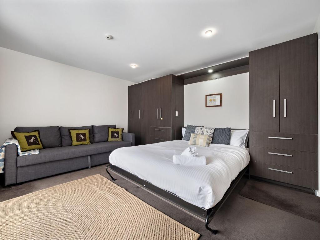 a bedroom with a large bed and a couch at Celesia 2 in Thredbo