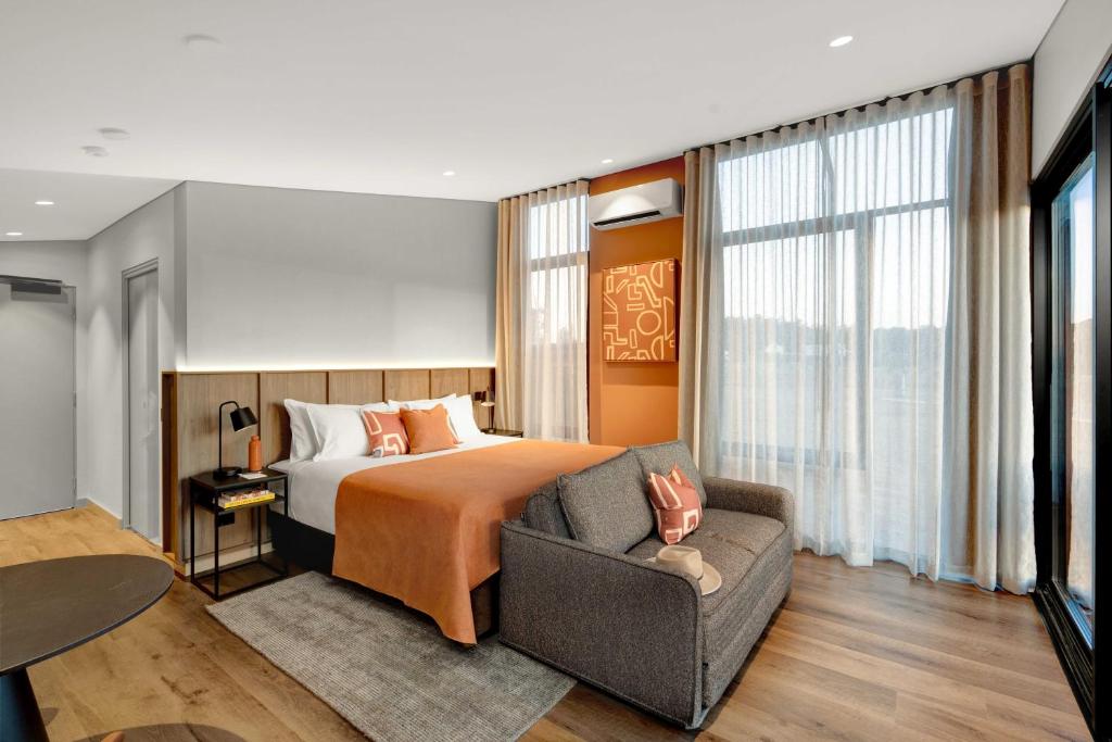 une chambre d'hôtel avec un lit et un canapé dans l'établissement The Lane Retreat, à Pokolbin