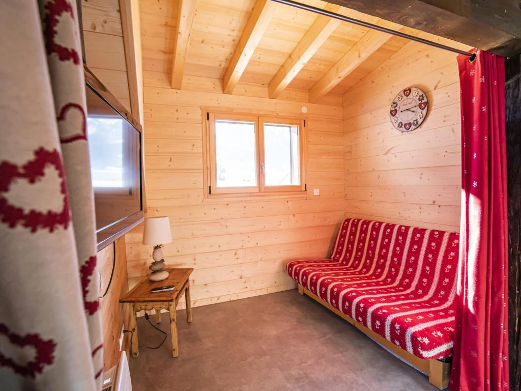 Cette chambre en bois comprend un canapé rouge. dans l'établissement Appartement 3 Pièces, 7 Pers, Châtel, 50m Remontées, Wifi, TV, Balcon, Animaux Acceptés - FR-1-676-104, à Châtel