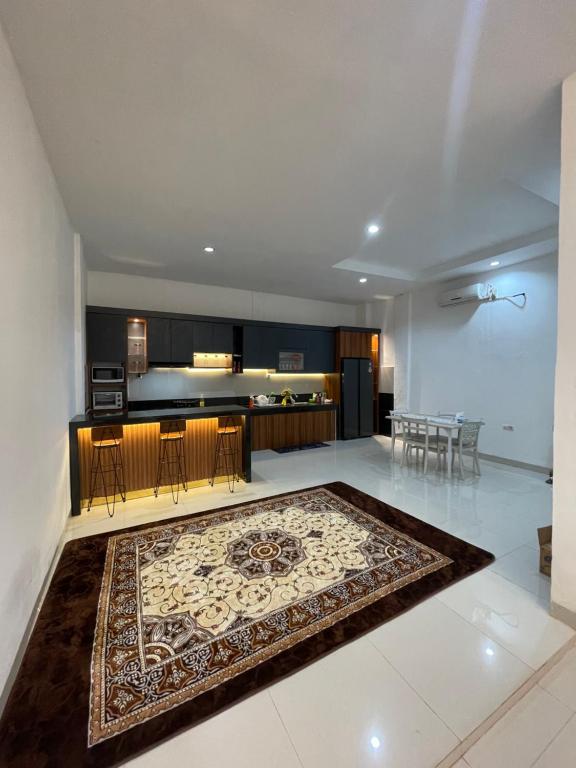 a living room and kitchen with a rug on the floor at Bagus house in Pekanbaru