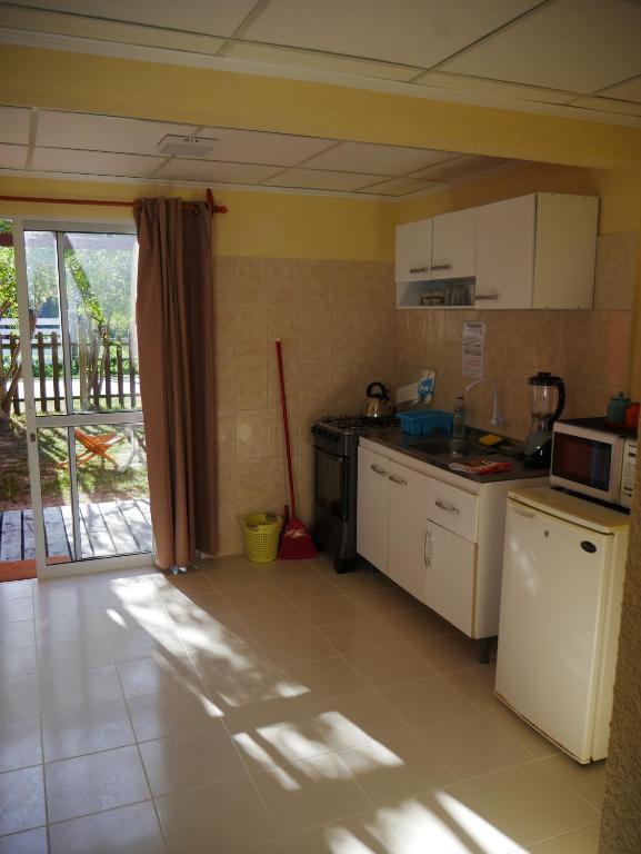 a kitchen with white appliances and a balcony at Aparts Dunas de Valizas in Barra de Valizas