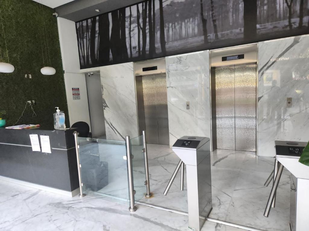 a lobby with two elevators and a marble wall at Ya no tenemos servicio in Mexico City
