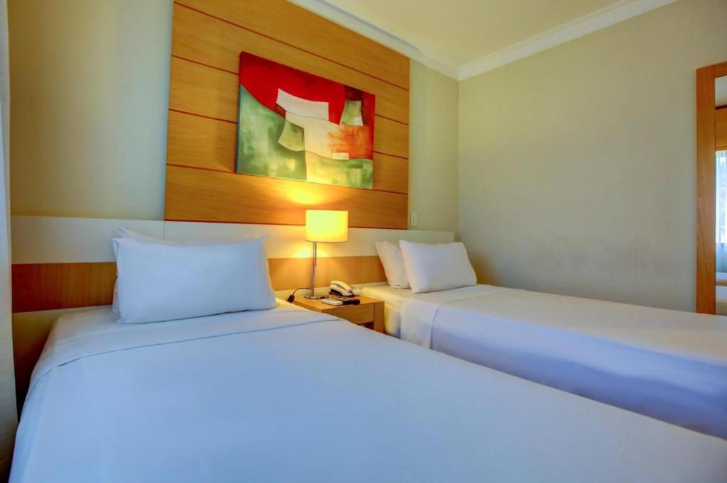 um quarto com 2 camas, um candeeiro e um quadro em Suite Congonhas - FLAT Aeroporto Congonhas em São Paulo