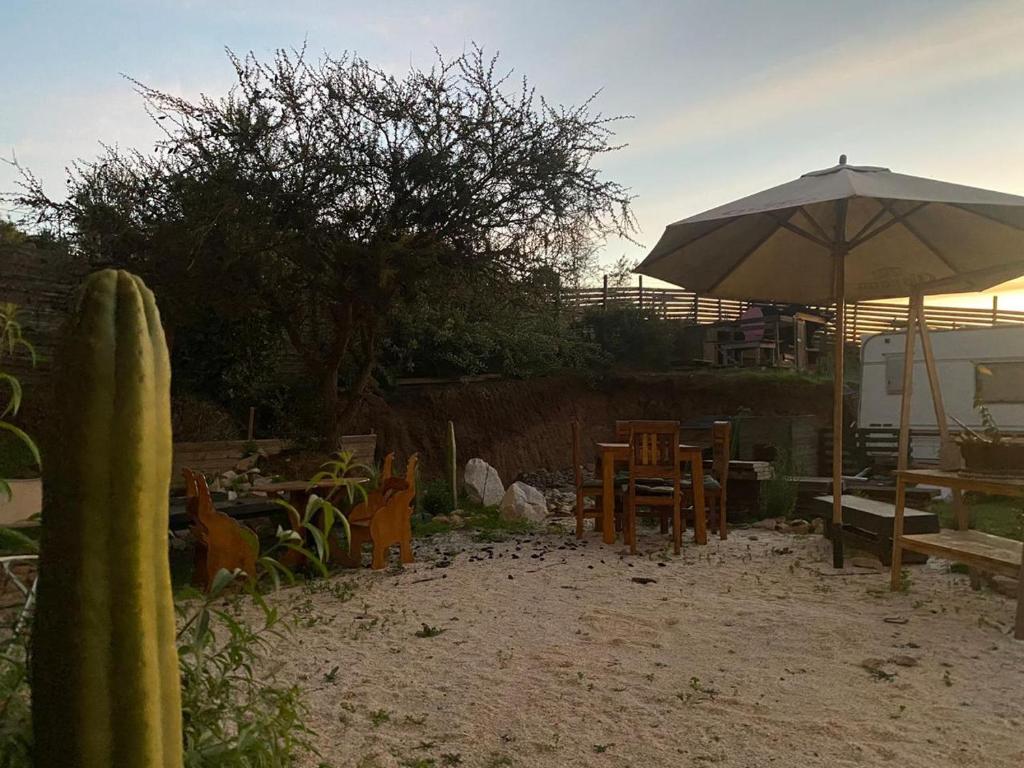 eine Terrasse mit einem Sonnenschirm, einem Tisch und Stühlen in der Unterkunft Hermosa Parcela en Concón in Concón
