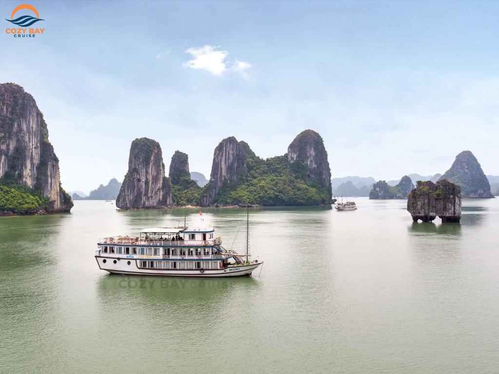a boat on the water with mountains in the background at Minh Hằng Cruise in Ha Long