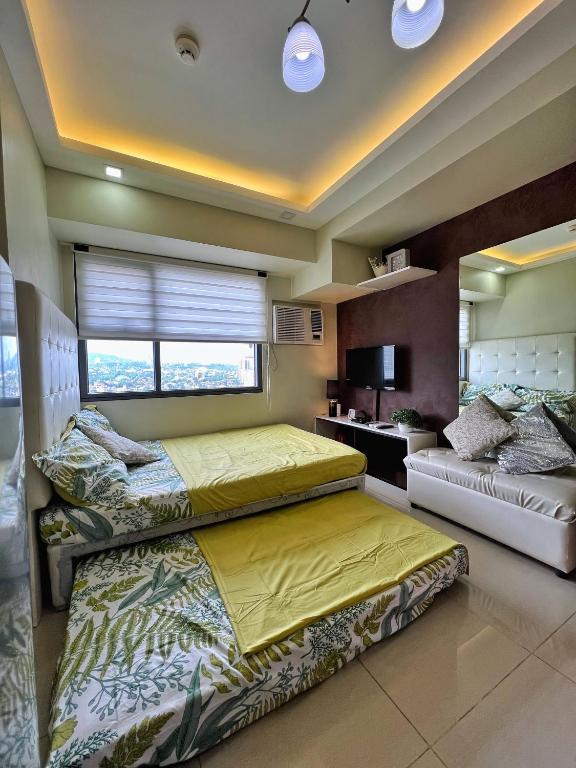 1 dormitorio con 2 camas y ventana en Horizons 101 Condo in Cebu City, en Cebú