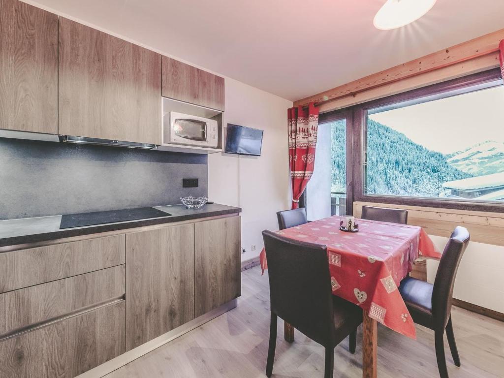 une cuisine et une salle à manger avec une table et une fenêtre dans l'établissement Studio 2* Châtel: 3 pers, balcon, parking, proximité remontées, centre, Forme d'O - FR-1-676-141, à Châtel