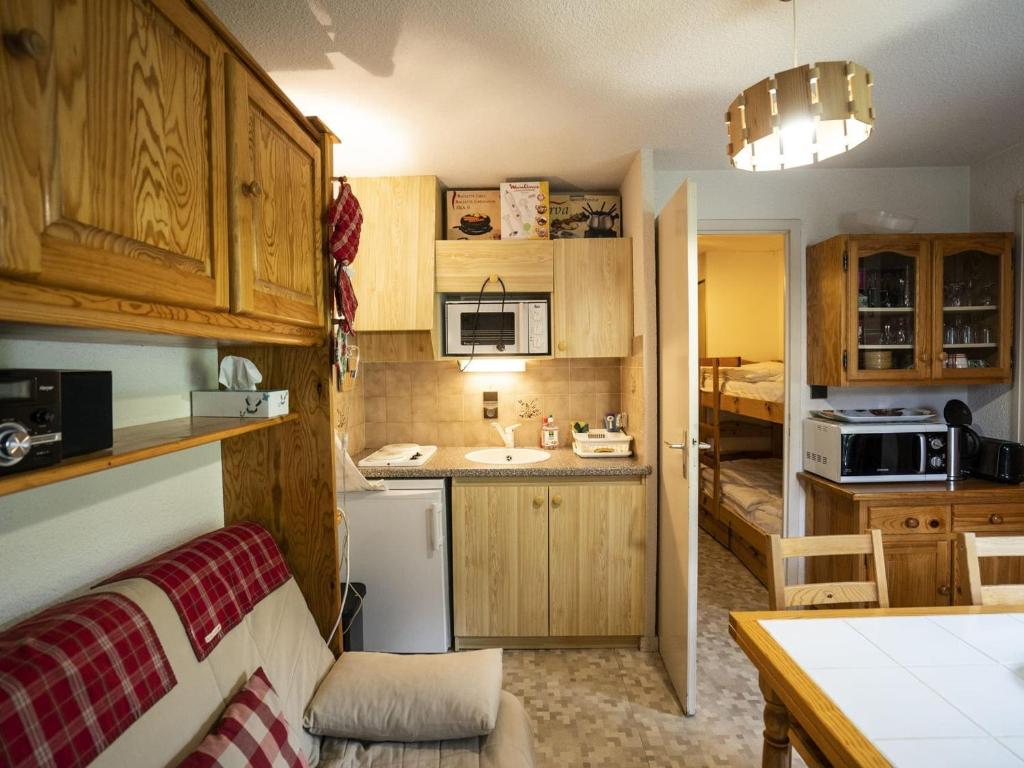 Il comprend une cuisine avec des placards en bois et un évier. dans l'établissement Appartement cosy avec balcon et parking à Châtel - 4 pers, proche centre et pistes - FR-1-676-151, à Châtel