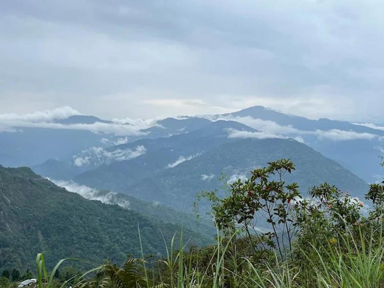 a view of a mountain range with clouds in the background at Hillsation Thulung Homestay in Kalimpong