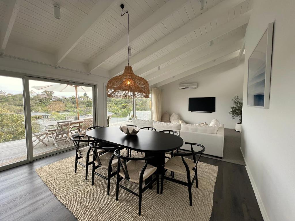 a dining room with a table and chairs and a couch at Rye Beach House - Sunset Views in Rye
