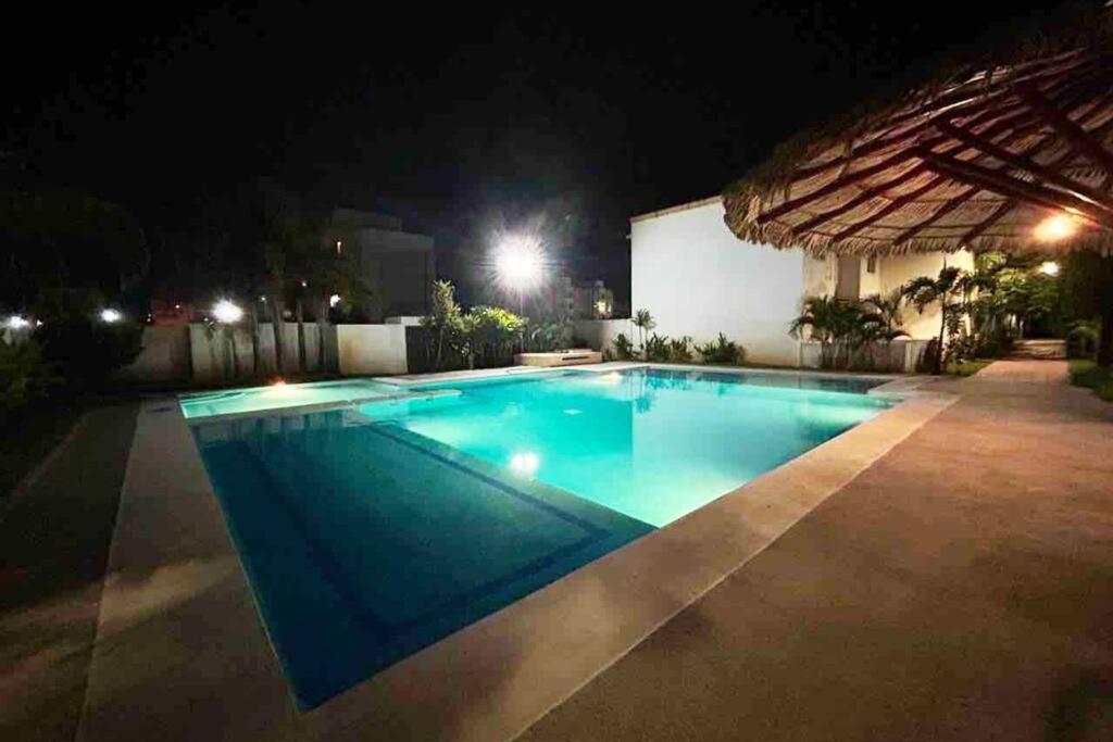 a swimming pool lit up at night at ¡Descubre tu oasis en Acapulco! Casa vacacional. in Acapulco