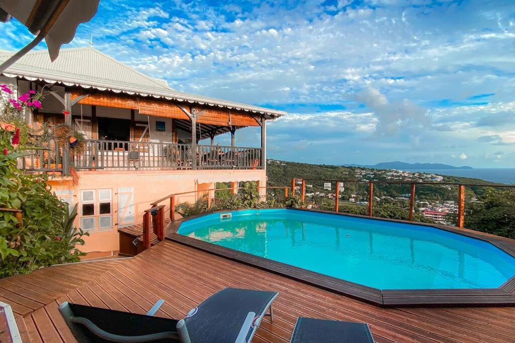 - une piscine au-dessus d'une terrasse avec un bâtiment dans l'établissement Villa T4 - Bleu Mer Caraïbes, à Case-Pilote