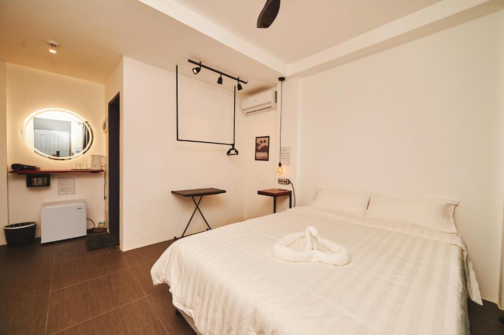 a bedroom with a white bed with a pair of shoes on it at Hotel Gray in Boracay in Boracay