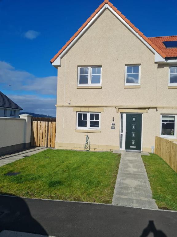 a house with a green lawn in front of it at Faillie in Inverness