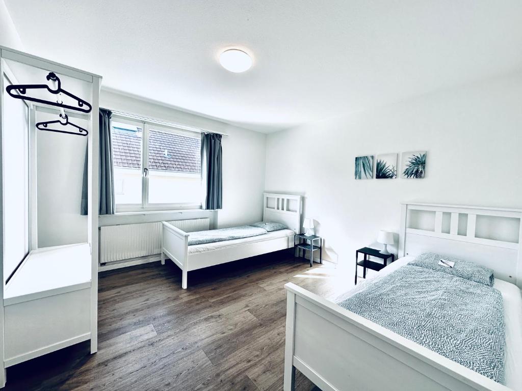 a white bedroom with a bed and a window at Monteurzimmer ZIMMERzuVERMIETEN in Deitingen Neumatt in Deitingen