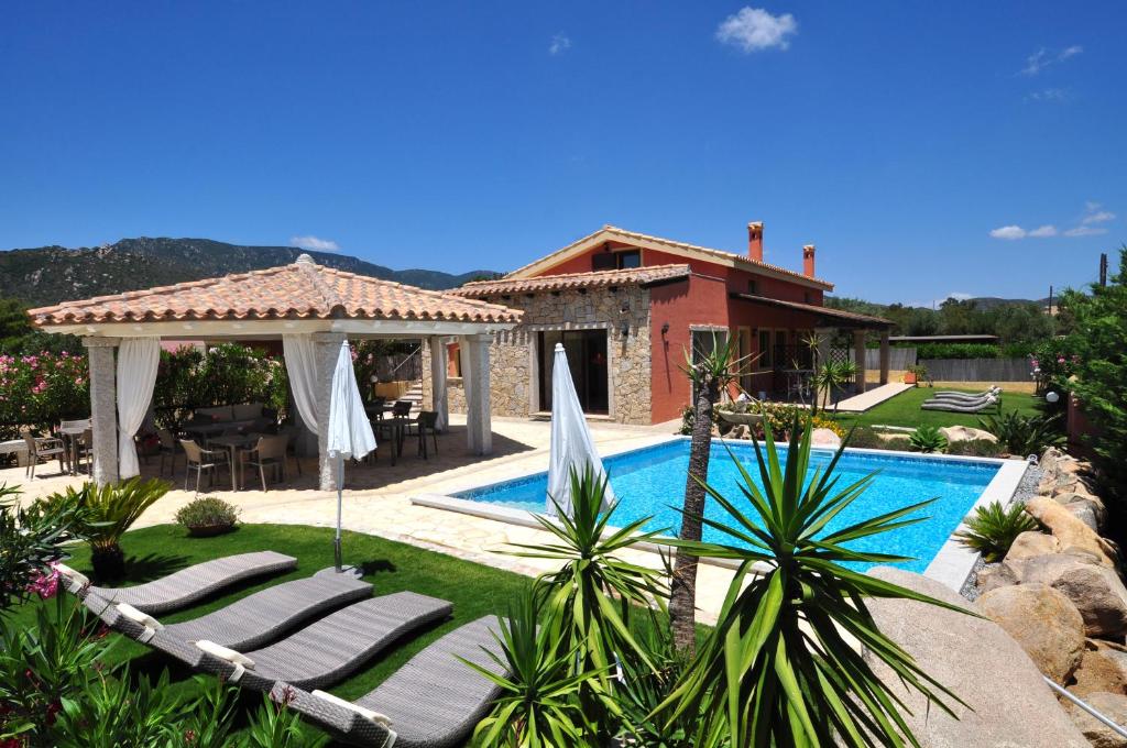 een villa met een zwembad en een huis bij B&B I Graniti Sardi in Villasimius