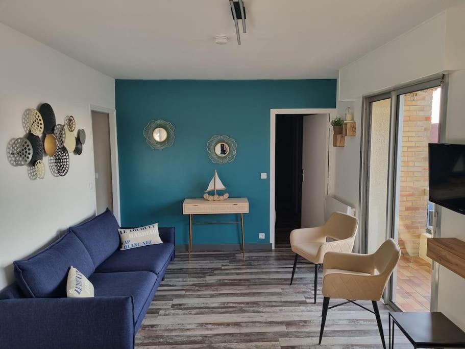 sala de estar con sofá azul y mesa en Sainte Cécile: appartement 2ch 6/7 pers, en Camiers